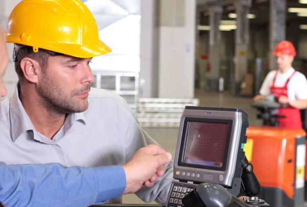 Construction workers looking at technology on a job site.