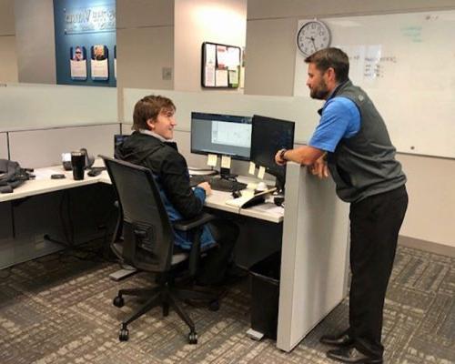 Two 澳门足彩app employees talking in the Dallas office